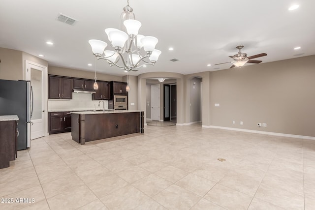 kitchen with arched walkways, stainless steel appliances, open floor plan, a ceiling fan, and recessed lighting