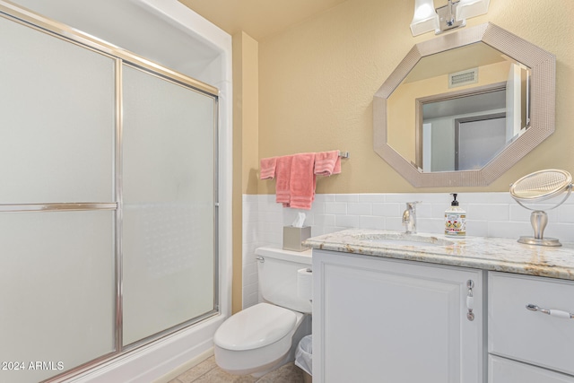 bathroom with vanity, tile patterned flooring, tasteful backsplash, a shower with shower door, and toilet