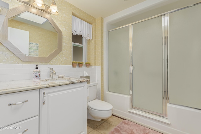 full bathroom with tile patterned floors, shower / bath combination with glass door, vanity, and toilet