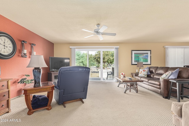 carpeted living room featuring ceiling fan and a textured ceiling