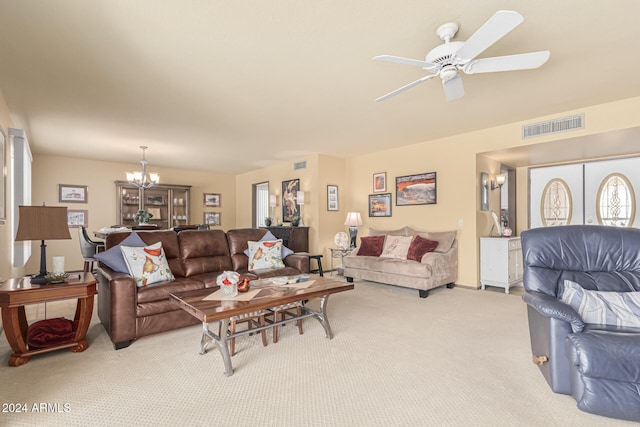 carpeted living room with ceiling fan with notable chandelier