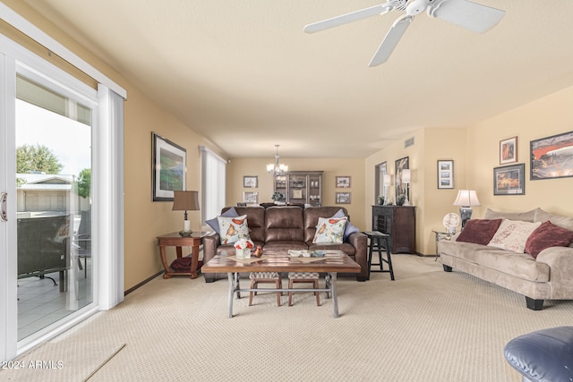 carpeted living room with ceiling fan with notable chandelier