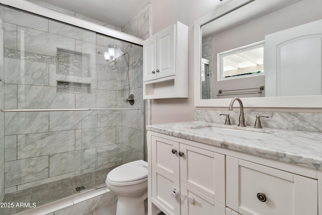 full bath with toilet, vanity, and a stall shower