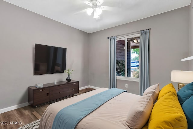 bedroom with baseboards, ceiling fan, and dark wood-type flooring