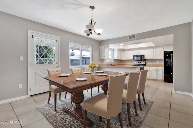 dining room with baseboards, visible vents, light tile patterned floors, and a chandelier