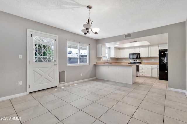 kitchen featuring light countertops, white cabinets, a peninsula, black appliances, and an inviting chandelier