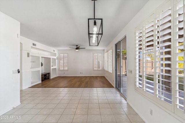 unfurnished living room with light tile patterned floors and ceiling fan