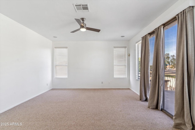 carpeted spare room featuring ceiling fan