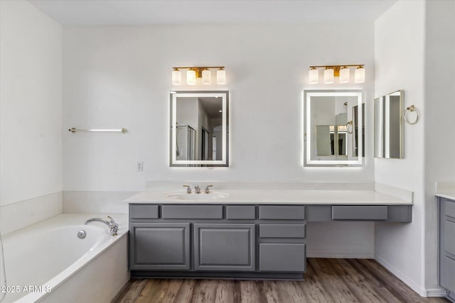 bathroom featuring hardwood / wood-style floors, vanity, and a bath