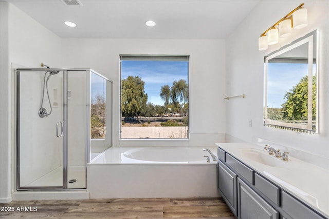 bathroom with independent shower and bath, vanity, and hardwood / wood-style flooring