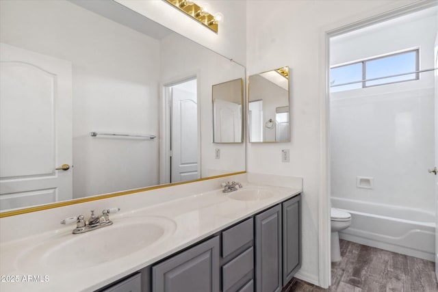 full bathroom featuring vanity, hardwood / wood-style flooring, shower / bathtub combination, and toilet