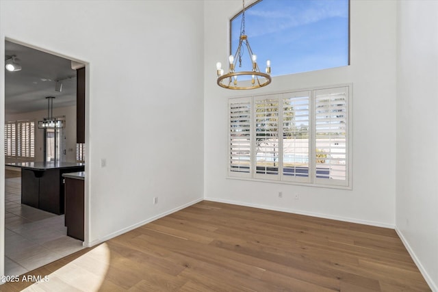 unfurnished dining area with hardwood / wood-style floors and a chandelier