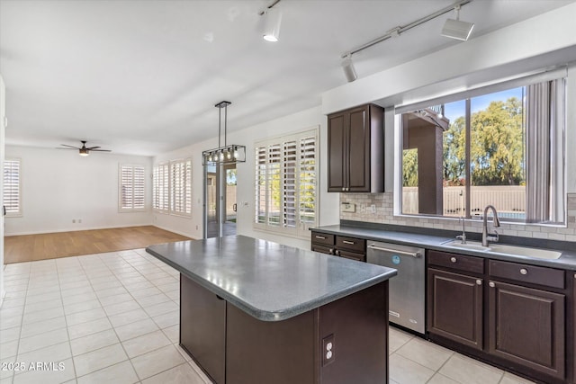 kitchen featuring sink, hanging light fixtures, dark brown cabinets, a center island, and stainless steel dishwasher