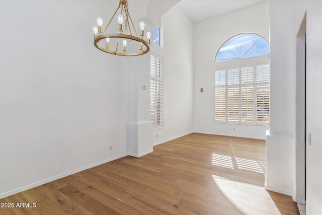 unfurnished dining area featuring a notable chandelier and light hardwood / wood-style floors