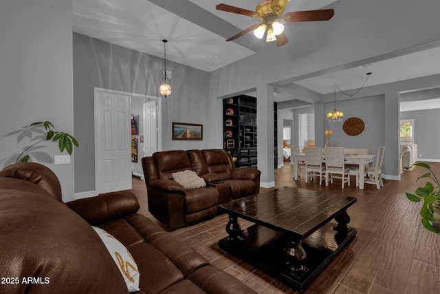 living room with dark hardwood / wood-style flooring and ceiling fan with notable chandelier