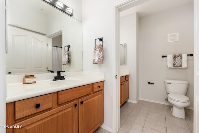 bathroom featuring toilet, baseboards, vanity, and tile patterned floors