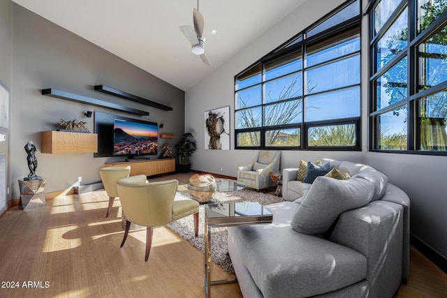 living room featuring hardwood / wood-style flooring, ceiling fan, and high vaulted ceiling