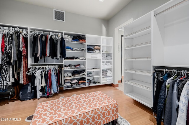 walk in closet with hardwood / wood-style floors