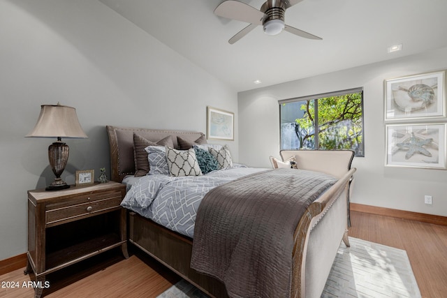 bedroom featuring light hardwood / wood-style flooring, ceiling fan, and lofted ceiling