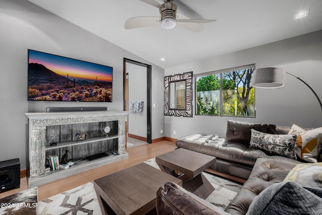 living room featuring ceiling fan, light hardwood / wood-style floors, and lofted ceiling