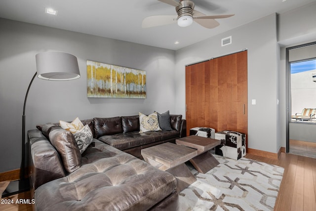 living room featuring light hardwood / wood-style flooring and ceiling fan