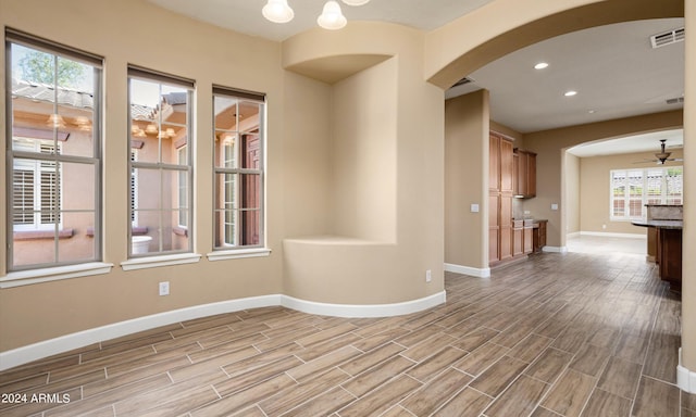 empty room with ceiling fan with notable chandelier