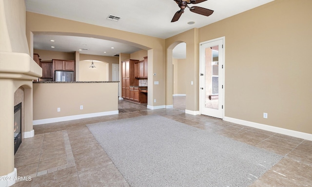 unfurnished living room with ceiling fan