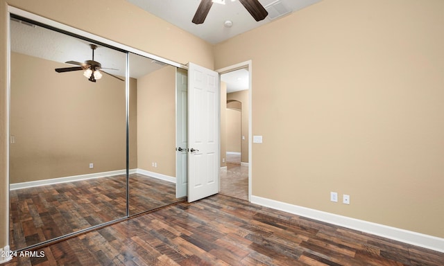 unfurnished bedroom with ceiling fan, dark hardwood / wood-style flooring, and a closet