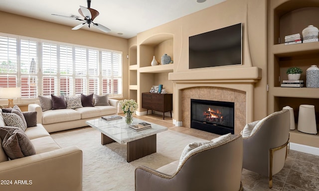 living room with built in shelves, ceiling fan, and a fireplace