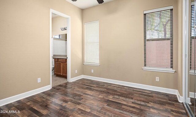 unfurnished bedroom featuring connected bathroom and dark hardwood / wood-style floors