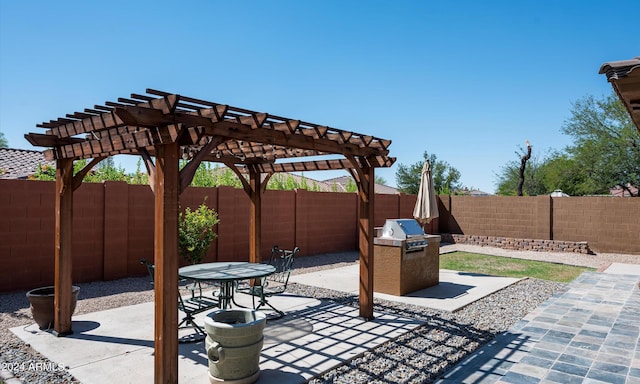 view of patio with area for grilling and a pergola