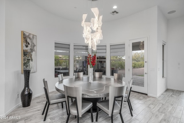 dining room featuring a high ceiling and light hardwood / wood-style flooring