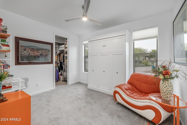 living area with light carpet and ceiling fan