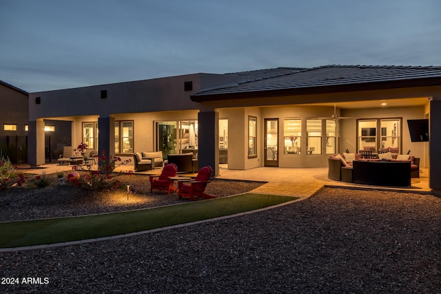 back of property with an outdoor living space and a patio