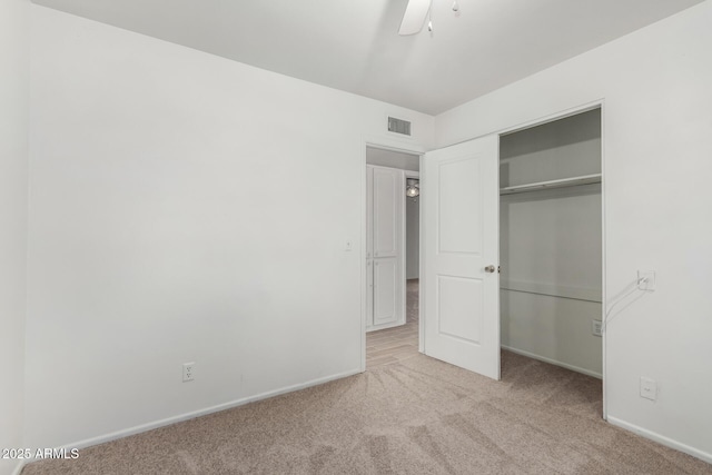 unfurnished bedroom with light colored carpet, ceiling fan, and a closet