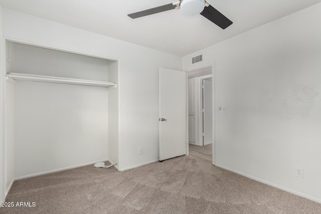 unfurnished bedroom featuring ceiling fan, light carpet, and a closet