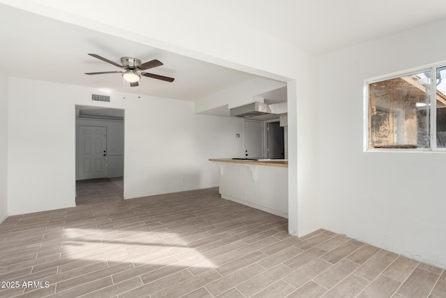 unfurnished living room with ceiling fan