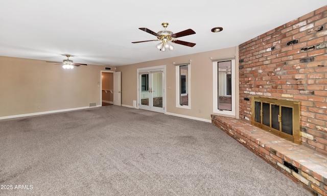 unfurnished living room with visible vents, a ceiling fan, a brick fireplace, carpet flooring, and baseboards