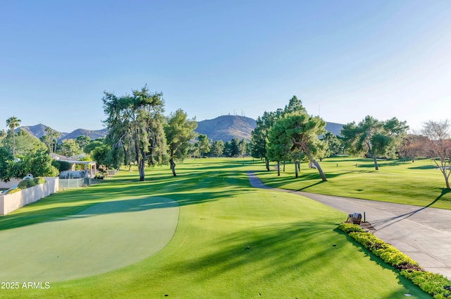 view of home's community featuring a mountain view, golf course view, and a lawn