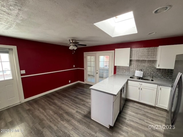 kitchen with white cabinetry, sink, kitchen peninsula, and appliances with stainless steel finishes