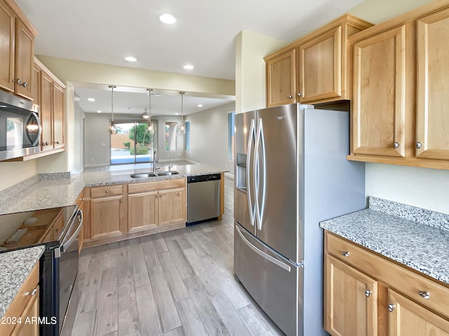 kitchen with decorative light fixtures, light hardwood / wood-style flooring, light stone countertops, appliances with stainless steel finishes, and sink