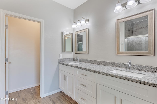 bathroom with vanity, wood-type flooring, and a shower with door