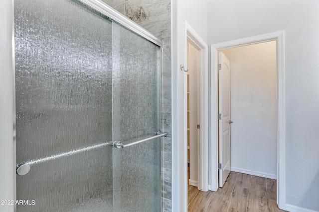 bathroom featuring wood-type flooring and walk in shower