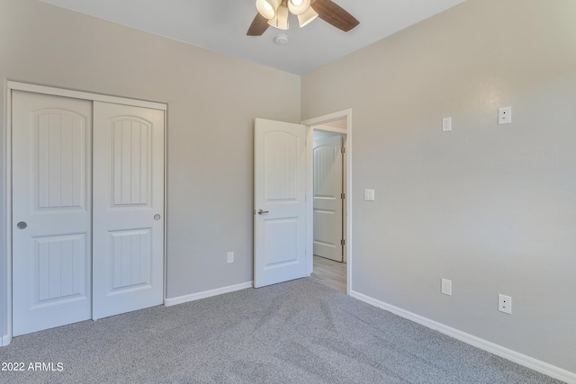 unfurnished bedroom featuring ceiling fan, light colored carpet, and a closet