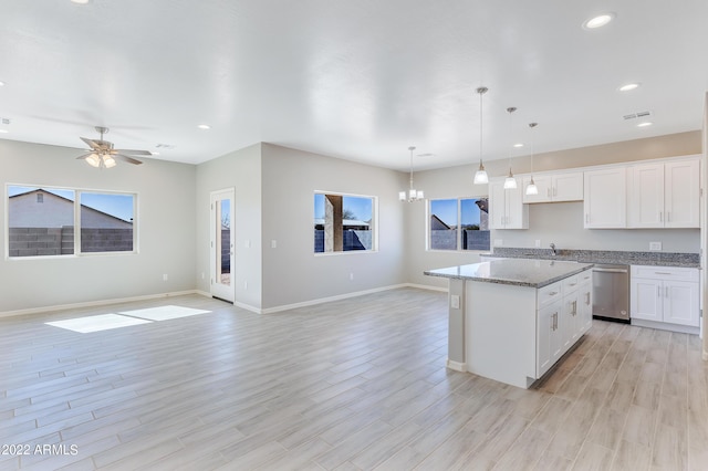 kitchen with white cabinetry, dishwasher, a kitchen island, and decorative light fixtures