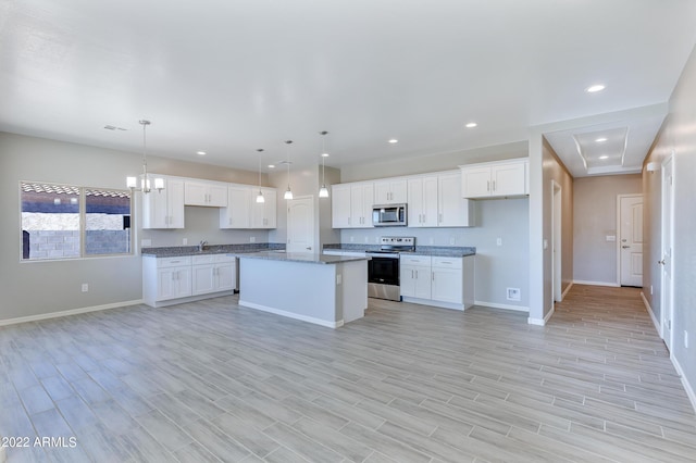 kitchen with a center island, stainless steel appliances, pendant lighting, light hardwood / wood-style floors, and white cabinets