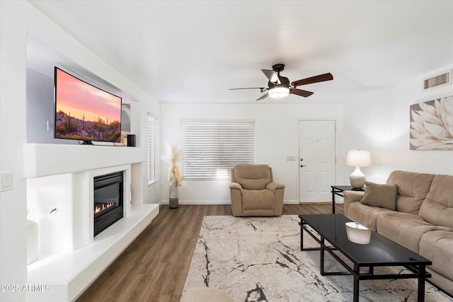 living room with dark wood-type flooring and ceiling fan