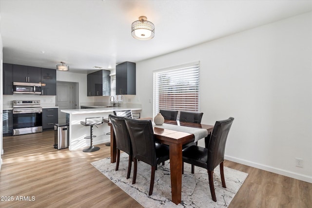 dining area featuring sink and light hardwood / wood-style flooring