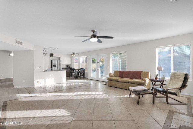 living room featuring ceiling fan, light tile patterned floors, and french doors