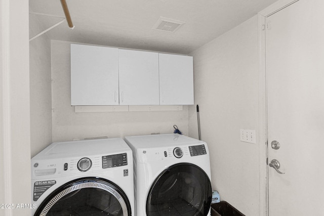 washroom featuring washing machine and clothes dryer and cabinets